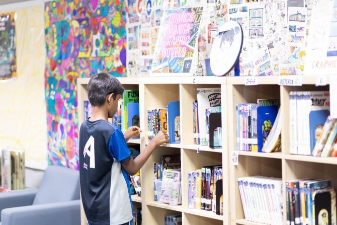 Image of student in library XCL American Academy