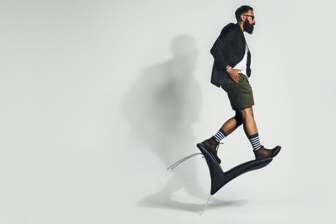 Man in suit and casual clothes balancing on a chair