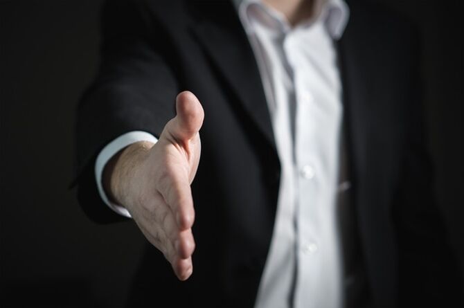 Image of outstretched hand offering handshake to seal a deal