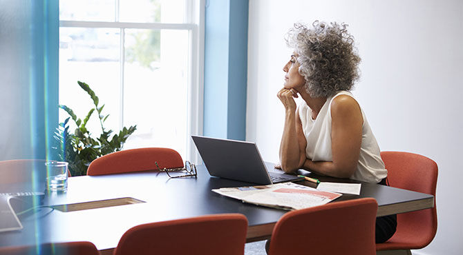 Image of a stylish, vibrant, well-dressed middle-aged woman with curly hair illustrating an article about managing an older and millennial workforce