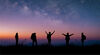 ilhouette group of young traveler and backpacker watched the star and milky way on top of the mountain with twilight sky. He enjoyed traveling and was successful when he reached the summit.