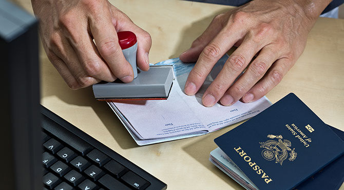 An immigration official stamps a passport